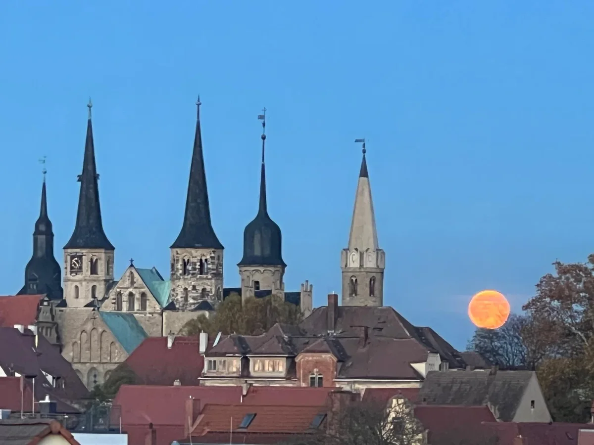 Die Domtürme von Merseburg vor blauem Abendhimmel mit aufgehendem Vollmond